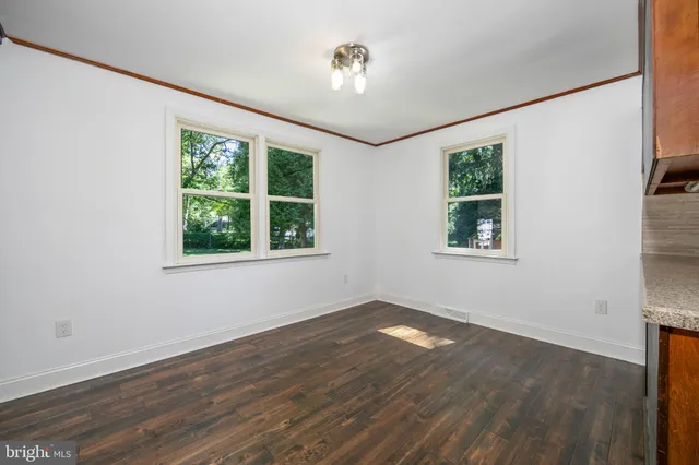 a kitchen view with wooden floor and electronic appliances