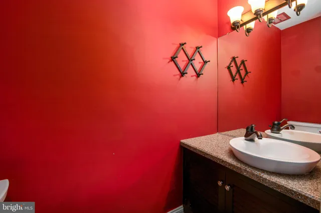 an empty room with wooden floor fireplace and windows