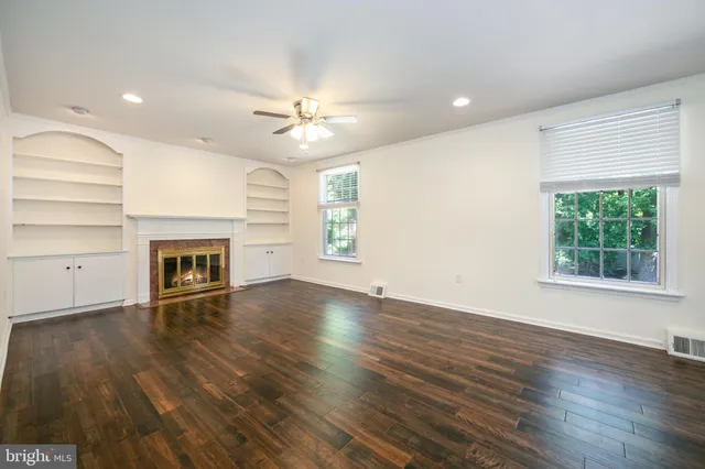 an empty room with wooden floor and fireplace