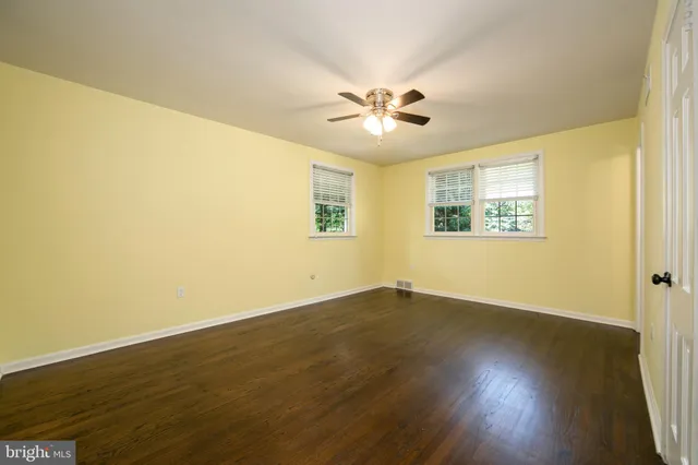 a view of wooden floor and a chandelier fan in a room