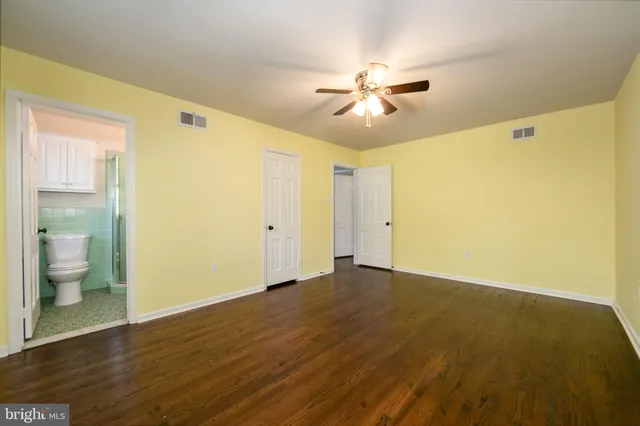 a bathroom with a toilet sink vanity and mirror