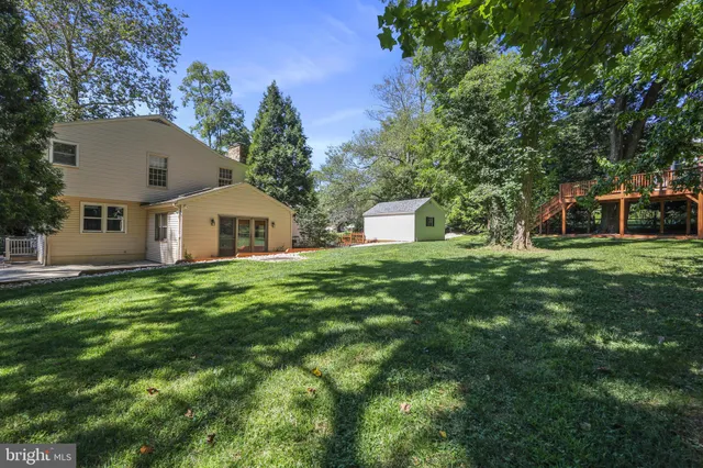 a view of a house with backyard and trees