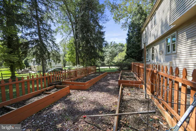 a view of white house with a big yard and large trees