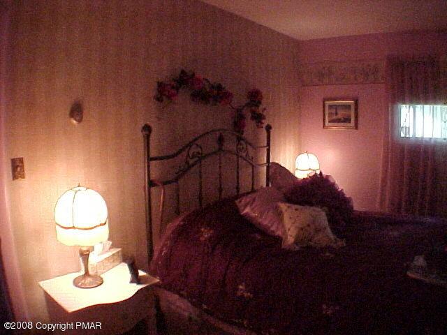 68 Woodland Road Mount Pocono, PA 18344 - Photo 9 of 11 a bedroom with bed and a table