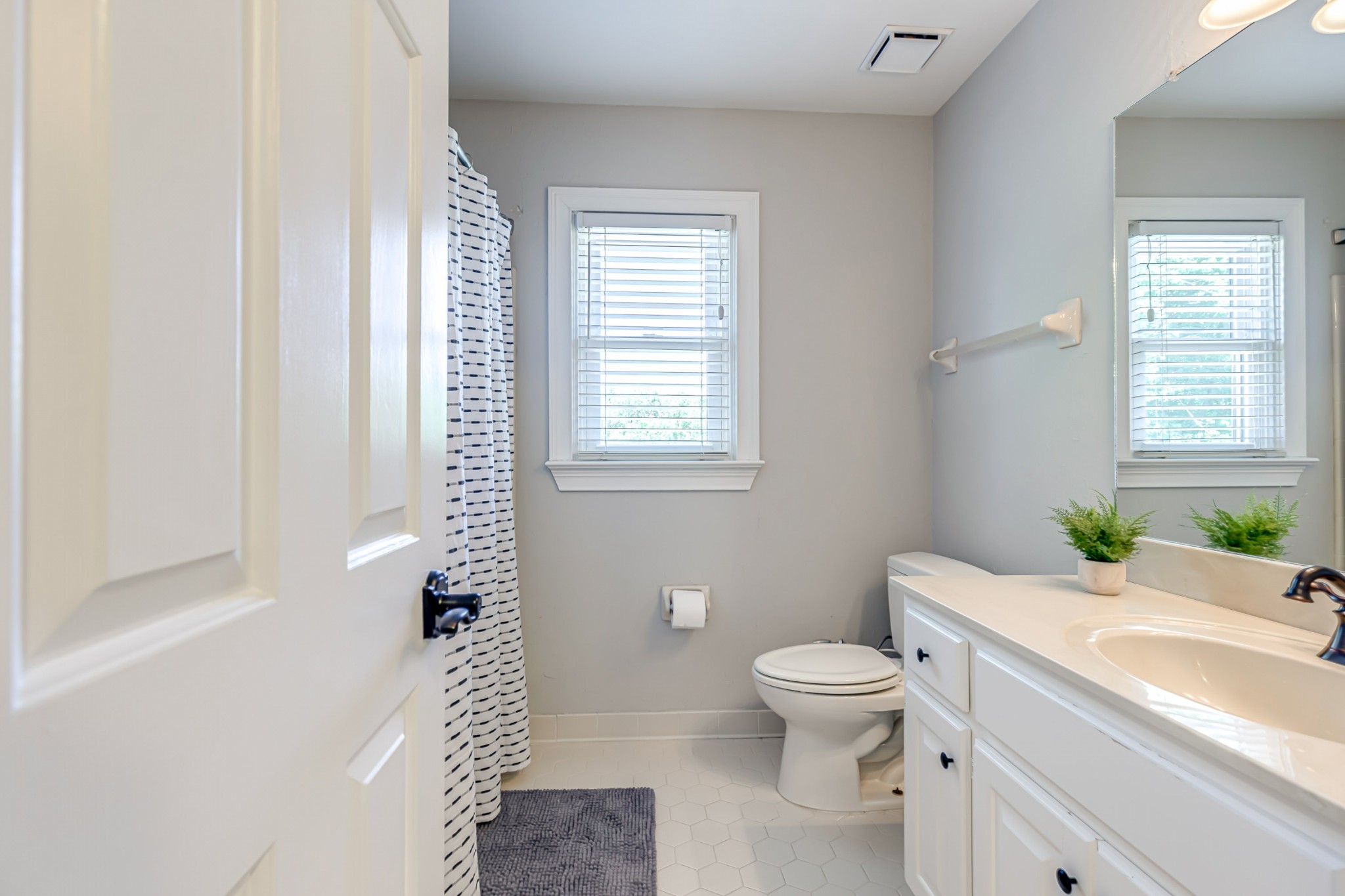 8204 Alamo Road Brentwood, TN 37027 - Photo 32 of 41 a bathroom with a granite countertop toilet a sink a mirror and a window