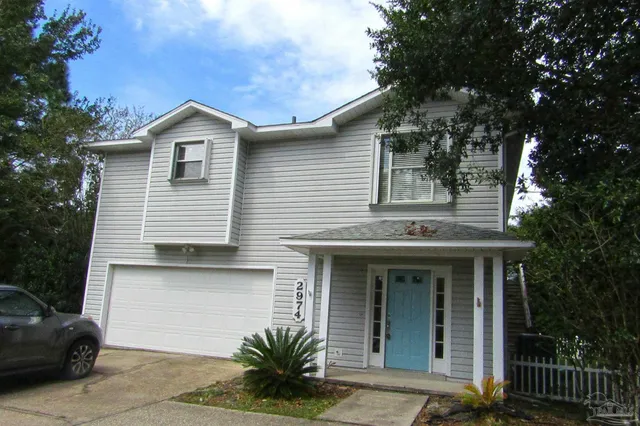 a view of a white house with large windows and a small yard
