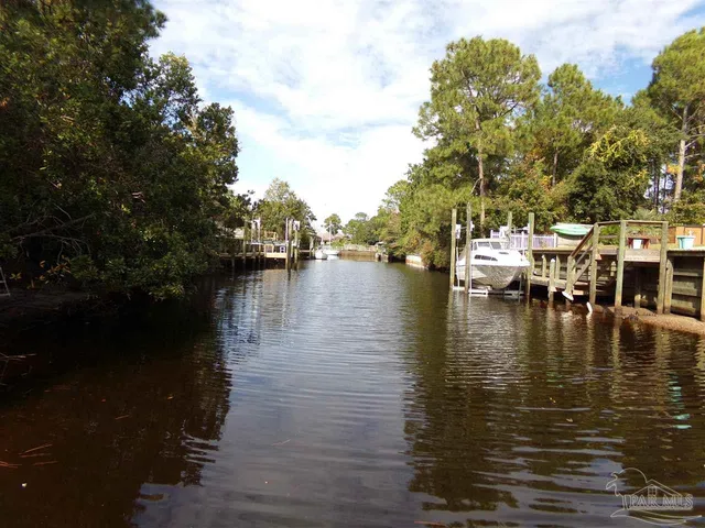 a view of water with boats and trees in the background
