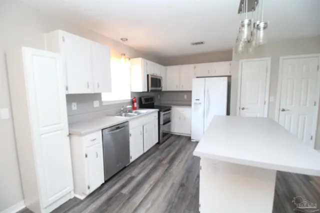 a kitchen with white cabinets and white appliances