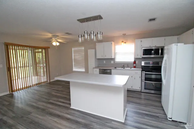 a view of kitchen with sink and refrigerator