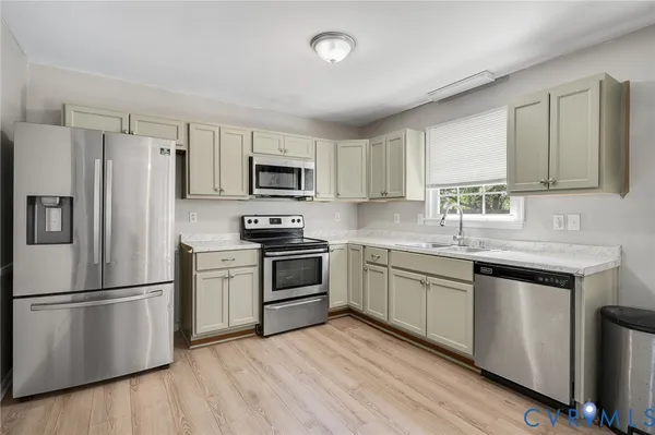 a kitchen with granite countertop a refrigerator stove and microwave