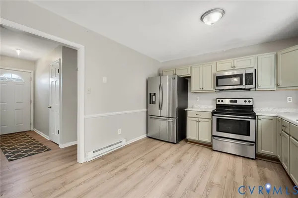 a kitchen with granite countertop a refrigerator and a stove top oven