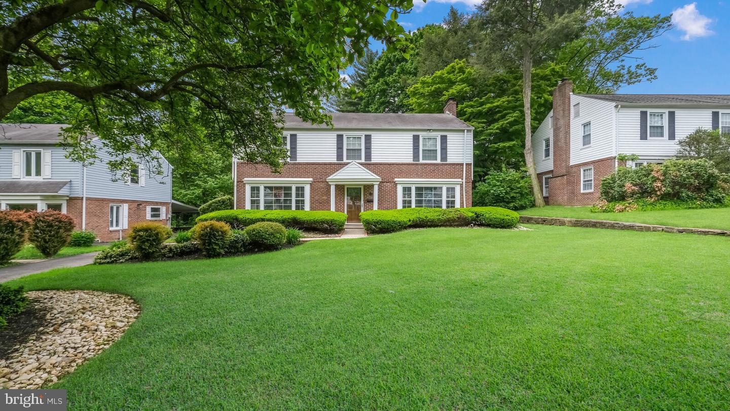 a front view of a house with a yard and trees