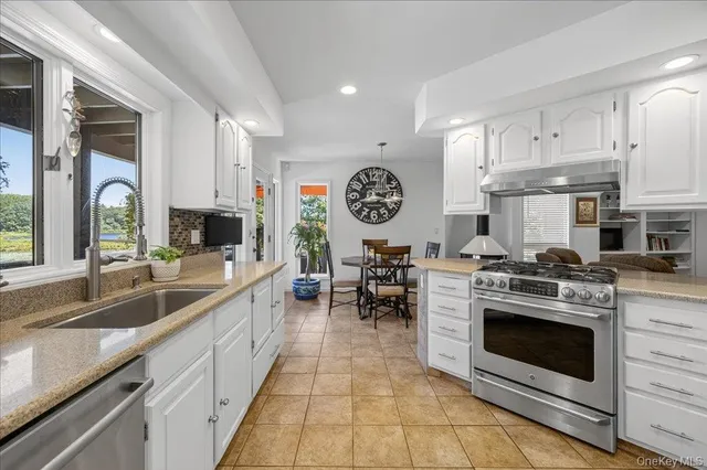 a kitchen with stainless steel appliances granite countertop a stove a sink and a granite counter tops