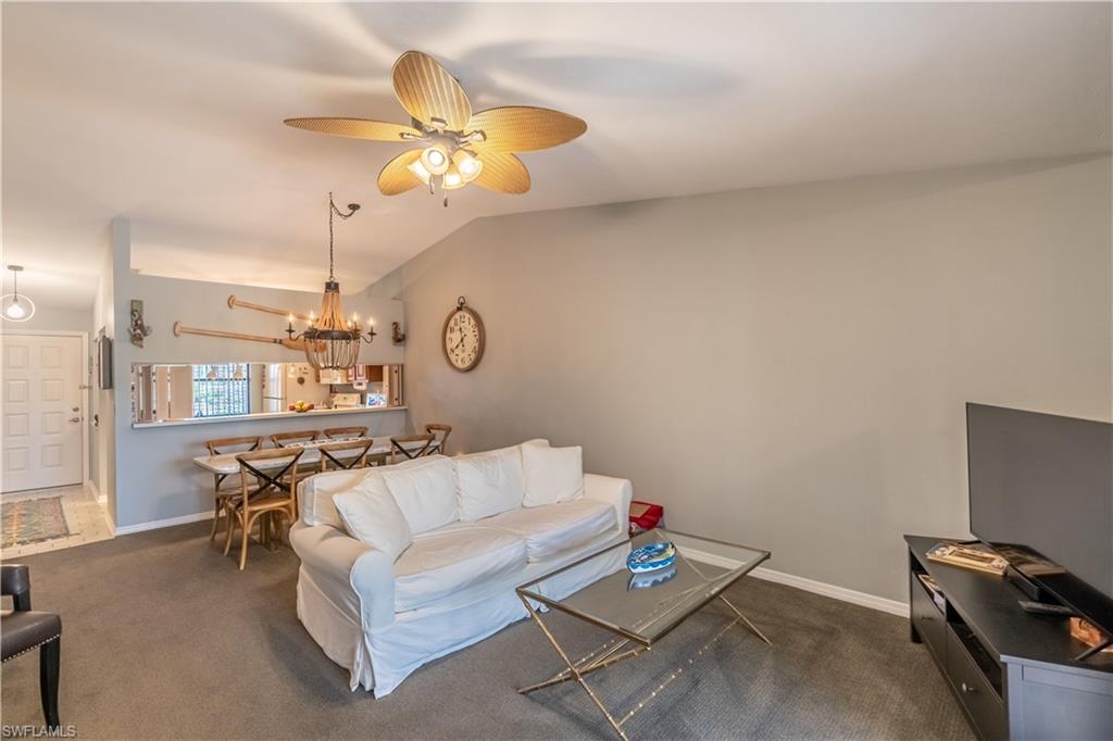 2048 Pine Isle Lane, Unit 2048 Naples, FL 34112 - Photo 12 of 50 a living room with furniture a chandelier fan and a window