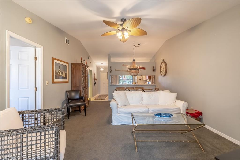 2048 Pine Isle Lane, Unit 2048 Naples, FL 34112 - Photo 13 of 50 a living room with furniture and a chandelier