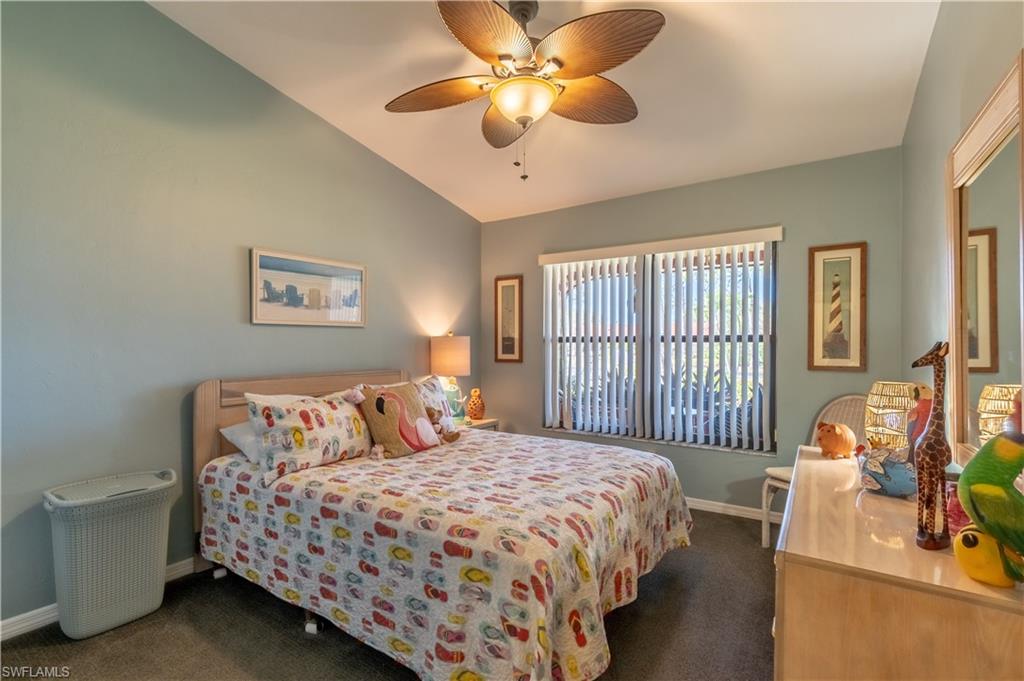 2048 Pine Isle Lane, Unit 2048 Naples, FL 34112 - Photo 14 of 50 a bedroom with a bed and a chandelier