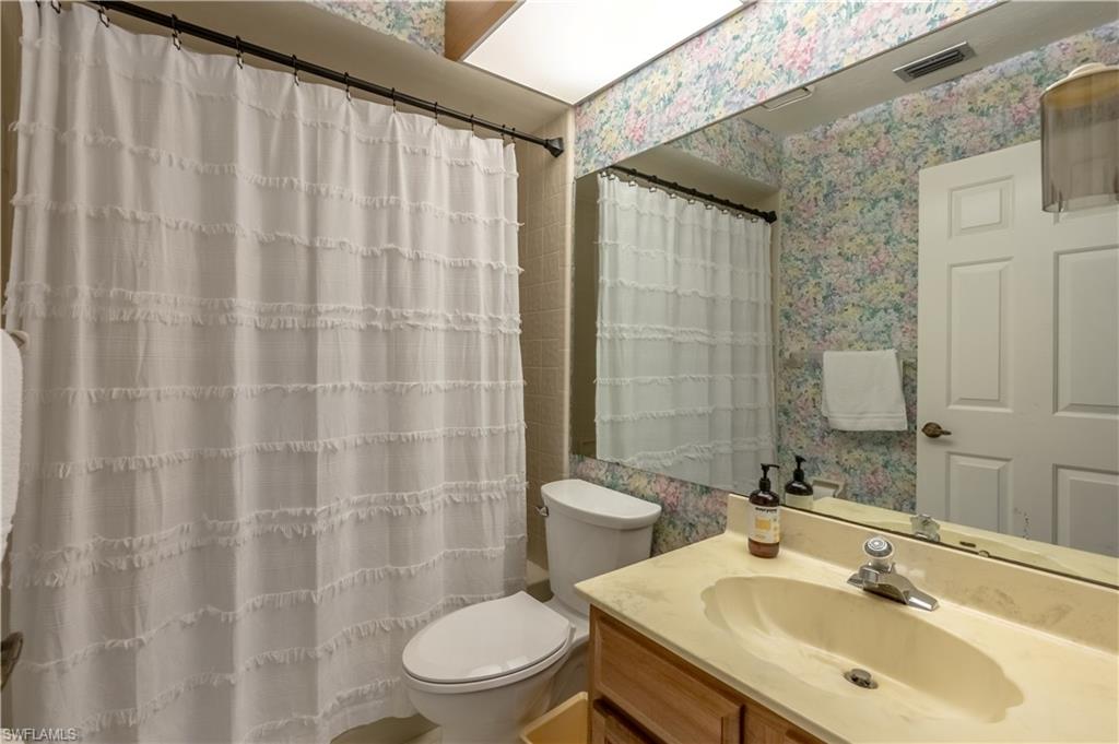 2048 Pine Isle Lane, Unit 2048 Naples, FL 34112 - Photo 16 of 50 a bathroom with a sink a toilet and shower curtain