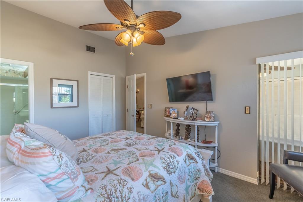 2048 Pine Isle Lane, Unit 2048 Naples, FL 34112 - Photo 19 of 50 a bedroom with a bed and a flat screen tv