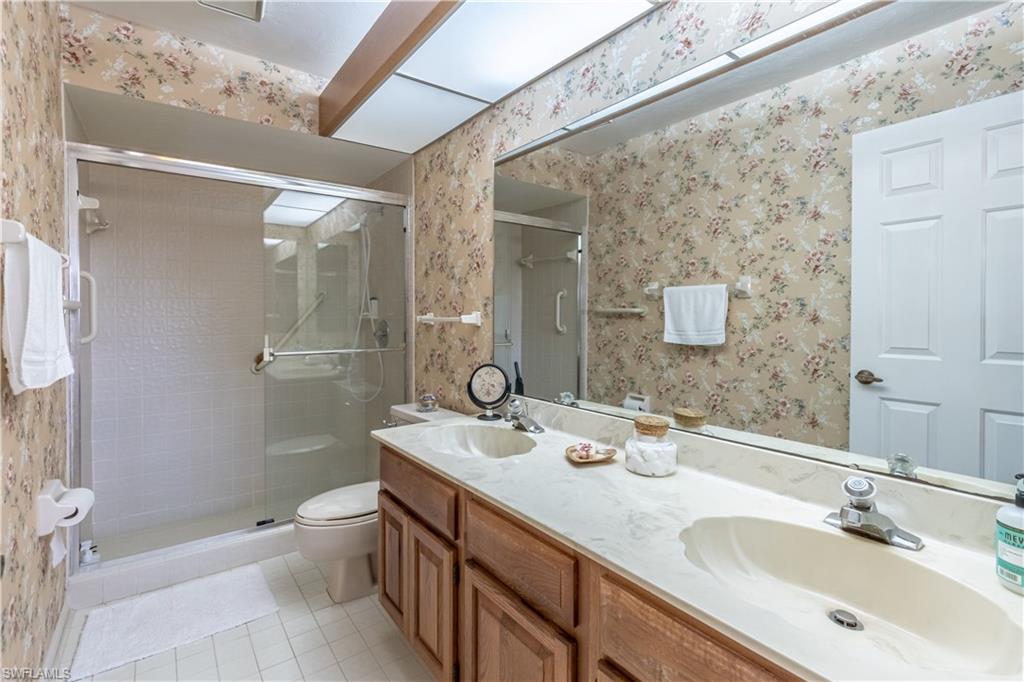 2048 Pine Isle Lane, Unit 2048 Naples, FL 34112 - Photo 20 of 50 a bathroom with a double vanity sink toilet and shower