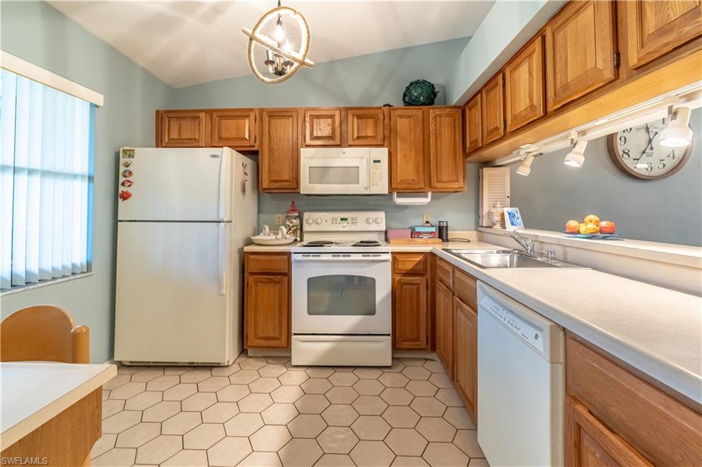 2048 Pine Isle Lane, Unit 2048 Naples, FL 34112 - Photo 2 of 50 a white kitchen with a sink a stove top oven and refrigerator