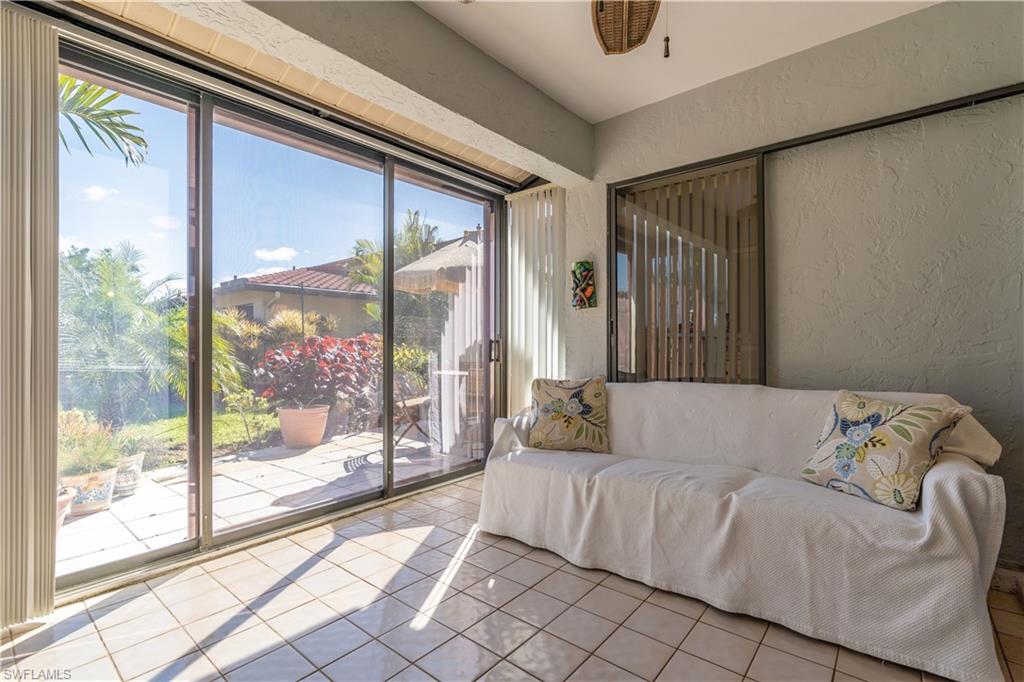 2048 Pine Isle Lane, Unit 2048 Naples, FL 34112 - Photo 22 of 50 a living room with furniture and a floor to ceiling window