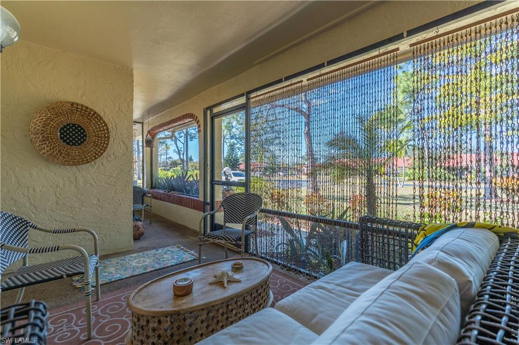 2048 Pine Isle Lane, Unit 2048 Naples, FL 34112 - Photo 24 of 50 a living room with furniture and a floor to ceiling window