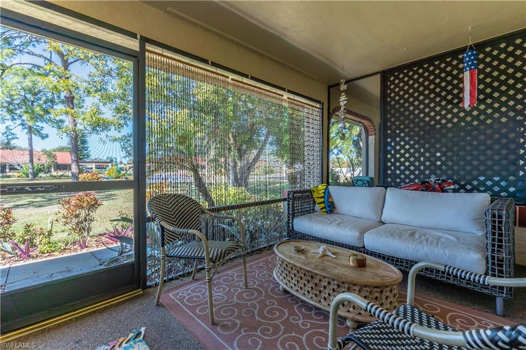 2048 Pine Isle Lane, Unit 2048 Naples, FL 34112 - Photo 25 of 50 a living room with furniture and a floor to ceiling window