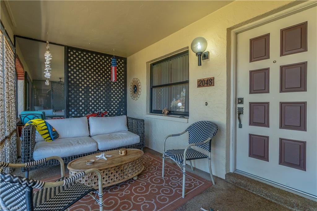 2048 Pine Isle Lane, Unit 2048 Naples, FL 34112 - Photo 26 of 50 a living room with furniture and a painting on the wall