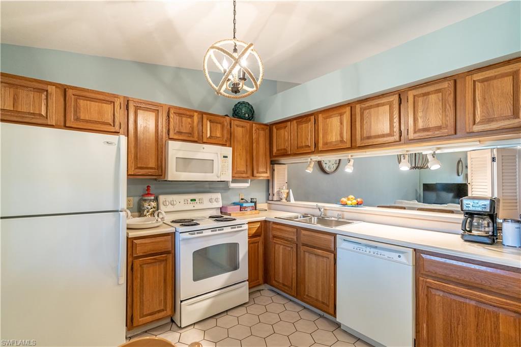 2048 Pine Isle Lane, Unit 2048 Naples, FL 34112 - Photo 3 of 50 a kitchen with a sink a stove cabinets and stainless steel appliances