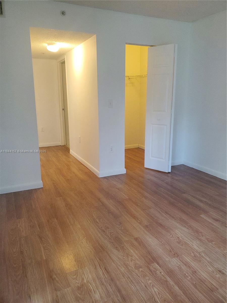 3874 Lyons Road, Unit 1126 Coconut Creek, FL 33073 - Photo 14 of 22 an empty room with wooden floor and windows