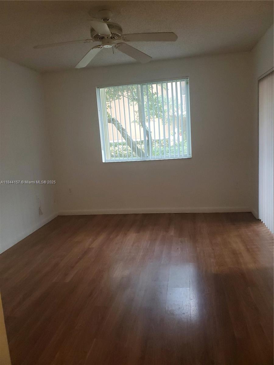 3874 Lyons Road, Unit 1126 Coconut Creek, FL 33073 - Photo 15 of 22 an empty room with wooden floor and windows