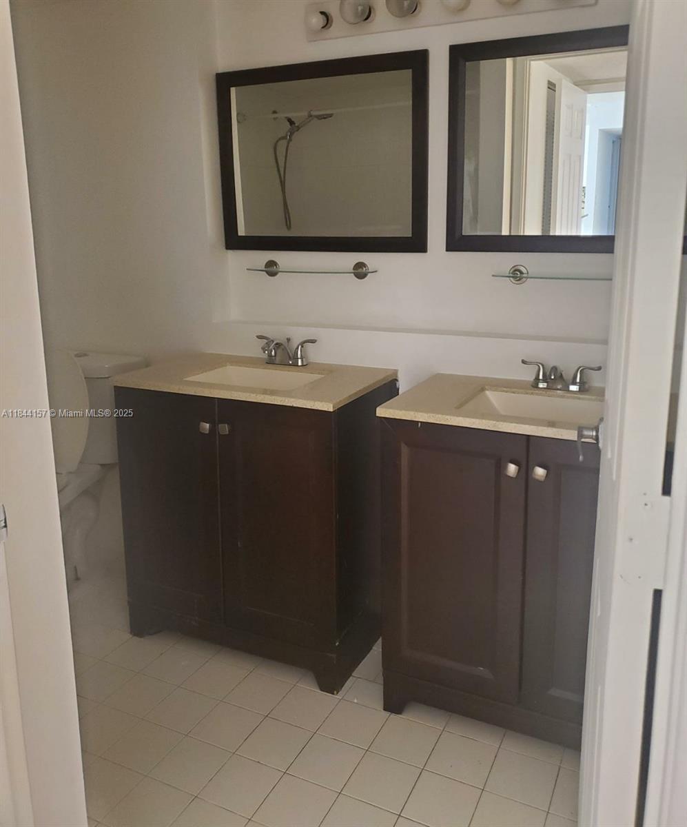 3874 Lyons Road, Unit 1126 Coconut Creek, FL 33073 - Photo 17 of 22 a bathroom with a sink vanity and mirror