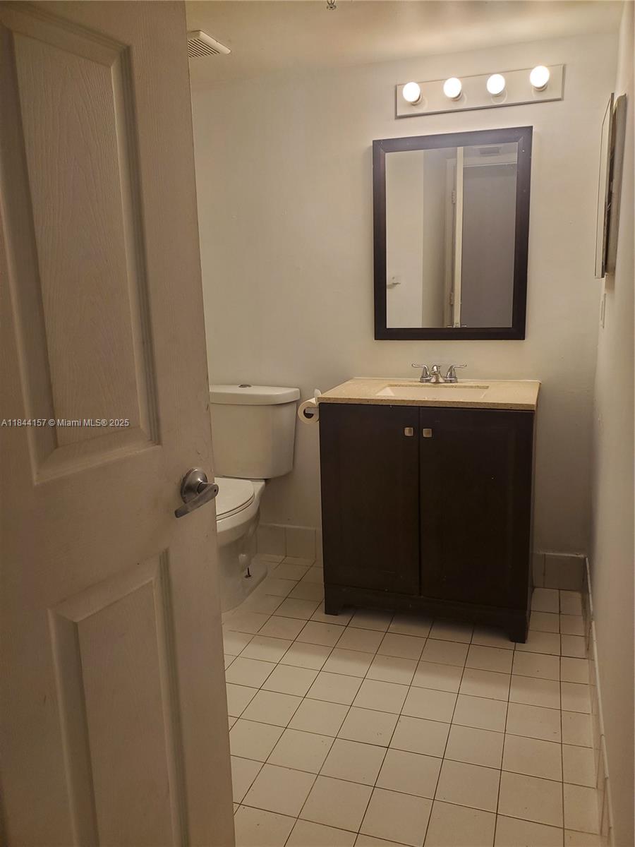 3874 Lyons Road, Unit 1126 Coconut Creek, FL 33073 - Photo 18 of 22 a bathroom with a sink vanity and mirror