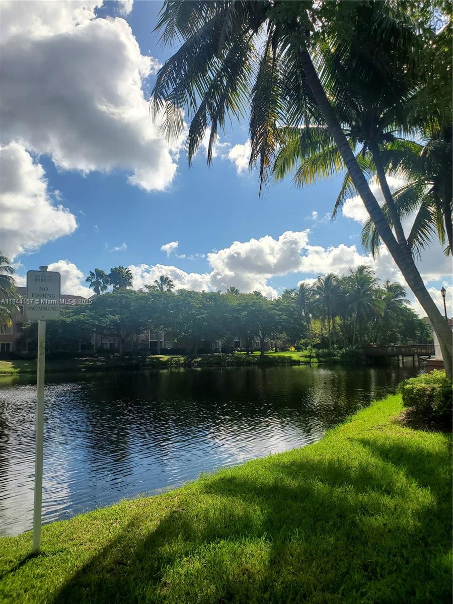 3874 Lyons Road, Unit 1126 Coconut Creek, FL 33073 - Photo 4 of 22 a view of a lake with a yard