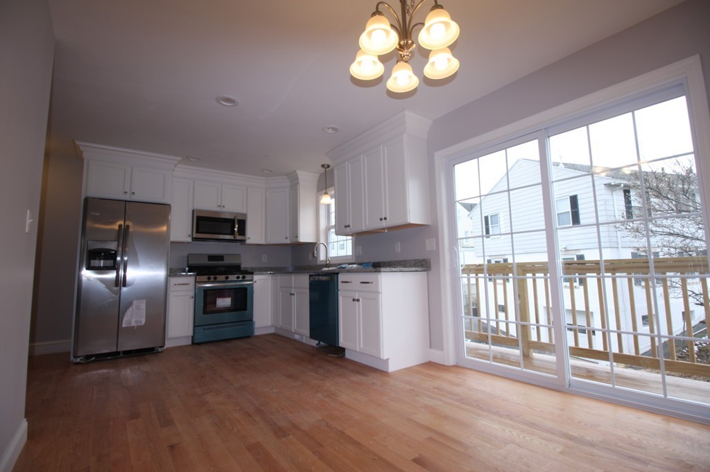 7 Butler Avenue, Unit B Lowell, MA 01852 - Photo 6 of 21 a kitchen with stainless steel appliances granite countertop a refrigerator a sink dishwasher a stove and a refrigerator with wooden floor