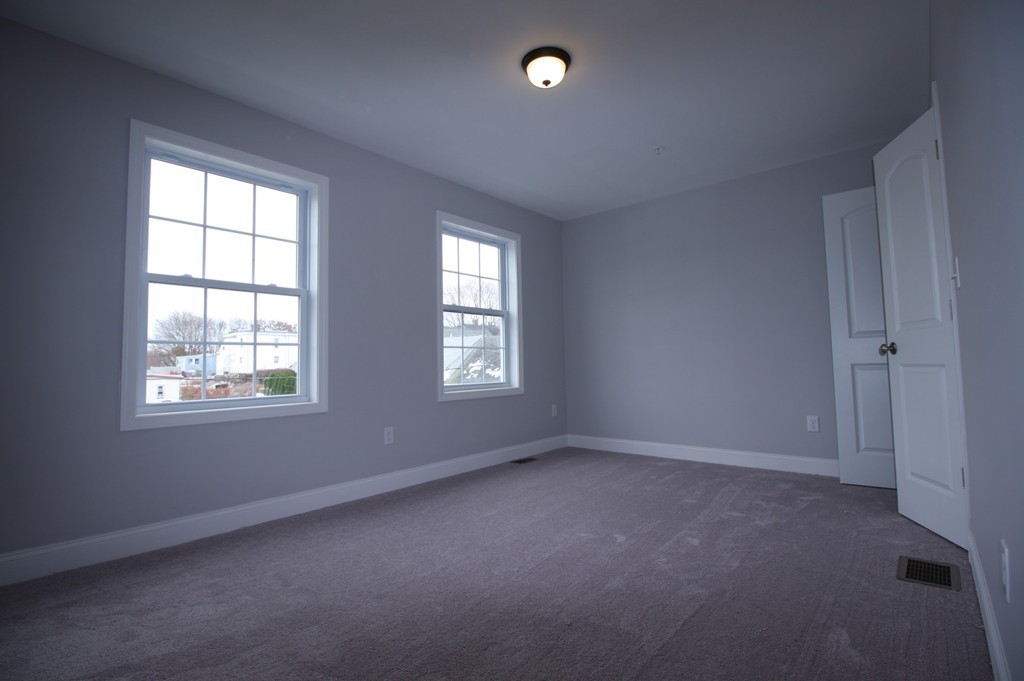 7 Butler Avenue, Unit B Lowell, MA 01852 - Photo 9 of 21 an empty room with windows