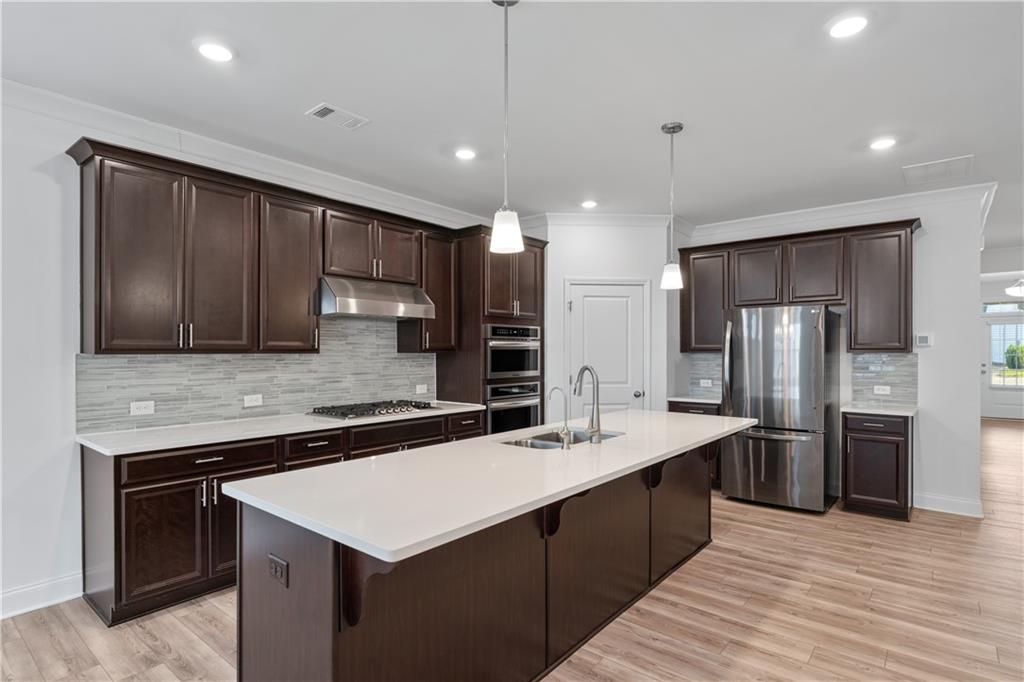 1204 Tahoe Place Canton, GA 30114 - Photo 17 of 73 a kitchen with stainless steel appliances kitchen island granite countertop a kitchen island a cabinets and wooden floor
