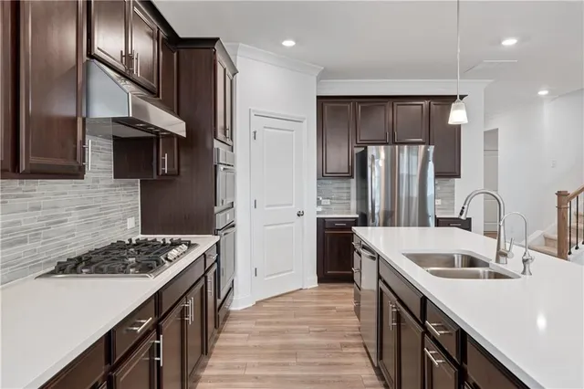 a large kitchen with stainless steel appliances granite countertop a large counter top and wooden floors
