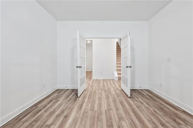 a view of a kitchen with wooden floor and white cabinets
