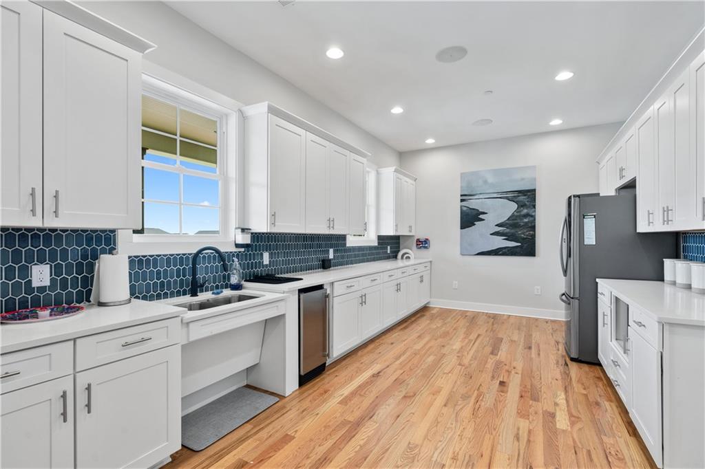 1204 Tahoe Place Canton, GA 30114 - Photo 58 of 73 a large kitchen with cabinets wooden floor and stainless steel appliances