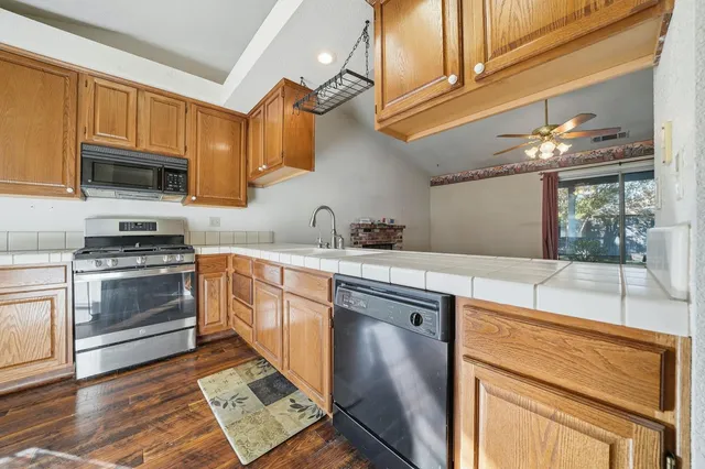 a kitchen with stainless steel appliances granite countertop a stove a sink and a microwave