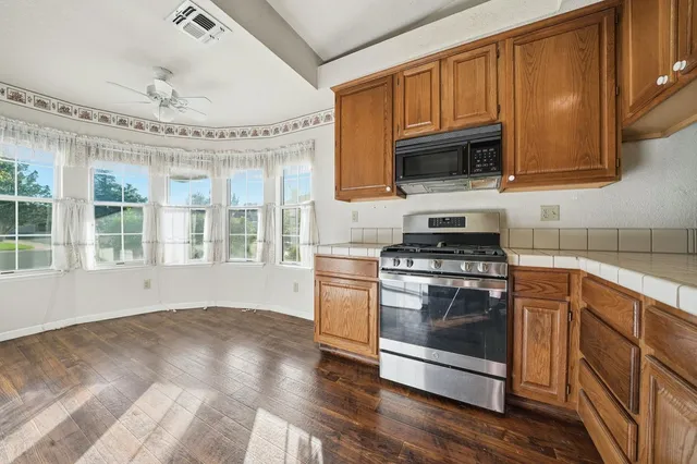 a kitchen with stainless steel appliances kitchen island sink refrigerator and stove