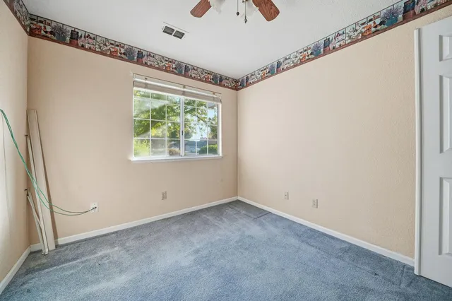 an empty room with a chandelier fan