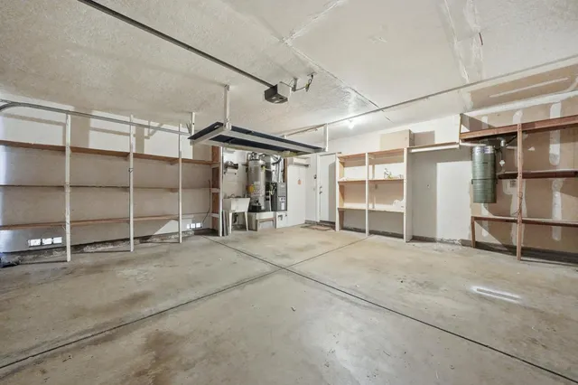 an empty room with a chandelier fan and windows