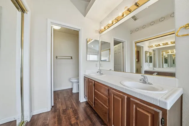 a view of a backyard with wooden fence and a large tree