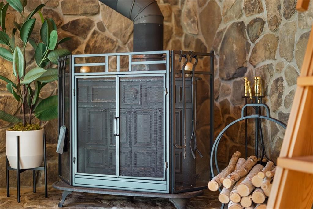 192 Mountain Laurel Road Emlenton, PA 16373 - Photo 11 of 50 The stone backdrop highlights the functional log burning stove.