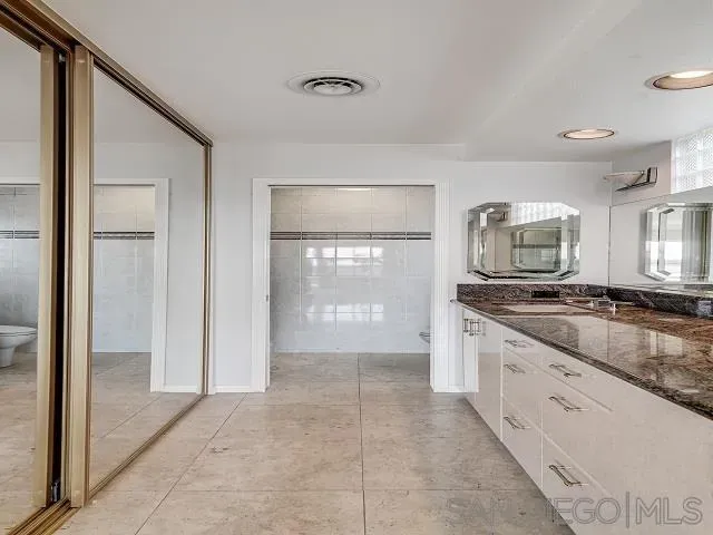 a large bathroom with a granite countertop sink a large mirror and a shower