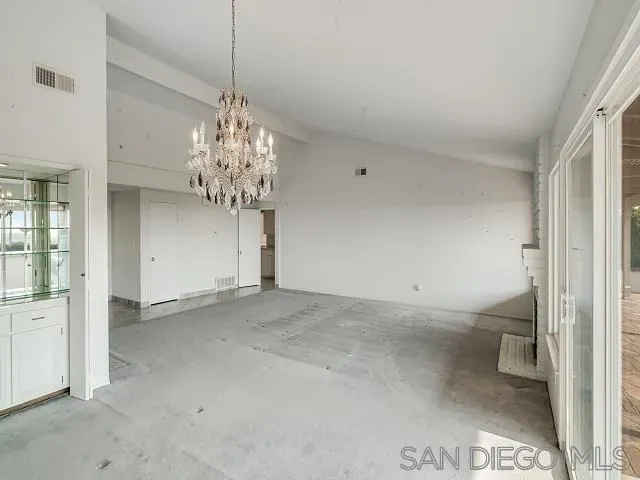 a view of a chandelier in big room and a bathroom