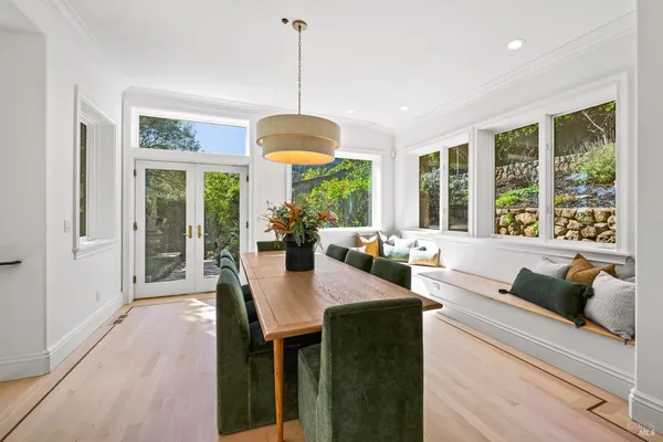a view of a dining room and livingroom with furniture wooden floor a chandelier