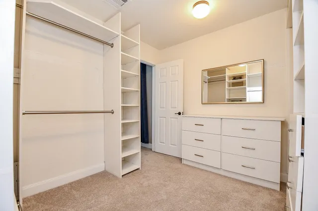 a view of walk in closet with empty racks